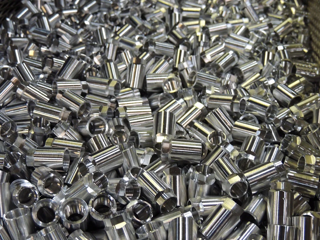 A bin of turned hex fittings